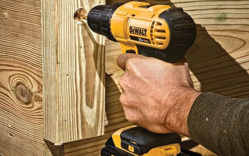 A DeWALT drill bearing into wood.