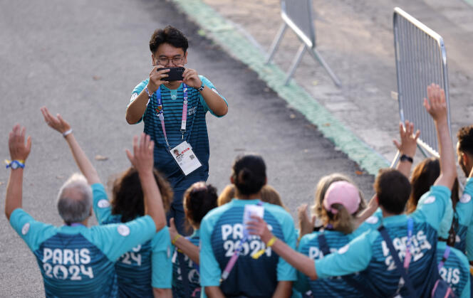 Paris 2024 Volunteers take a photograph on the Champs-Elysees ahead of the opening ceremony of the Paralympic Games, August 28, 2024. 