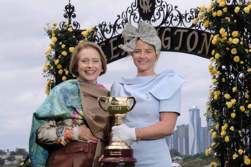 Trainer Gai Waterhouse and Melbourne Cup-winning jockey Michelle Payne stand at Flemington racecourse with the Melbourne Cup.