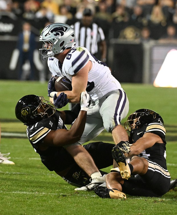 Colorado's Nikhai Hill-Green, left, and Preston Hodge bring down Kansas...