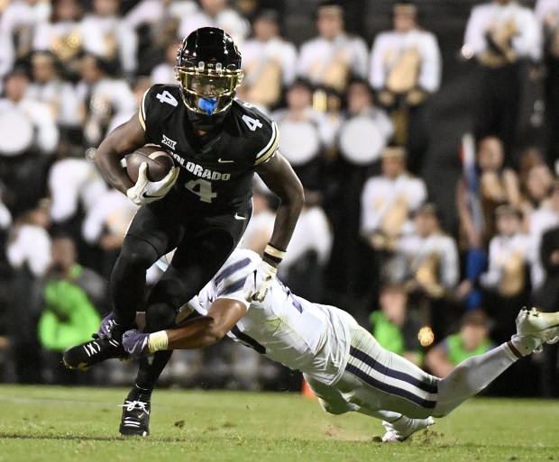 Colorado receiver Omarion Miller tries to break the tackle from...