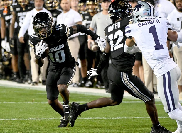 Colorado's LaJohntay Wester, left, gets a block from Travis Hunter...