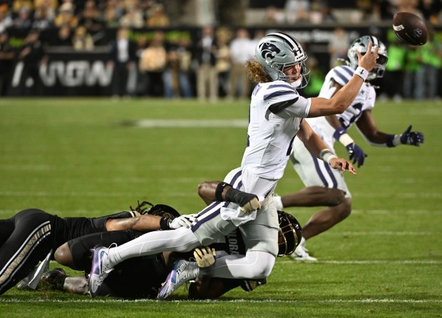 Colorado's Taje McCoy, center, and Cam’Ron Silmon-Craig tackle Kansas State...