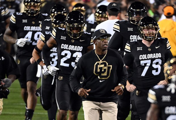 Colorado head football coach Deion Sanders leads the team onto...