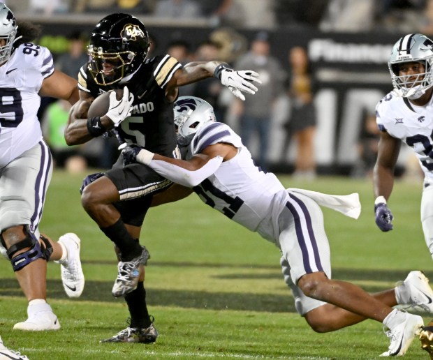 Colorado's Jimmy Horn Jr. tries to pull away from the...
