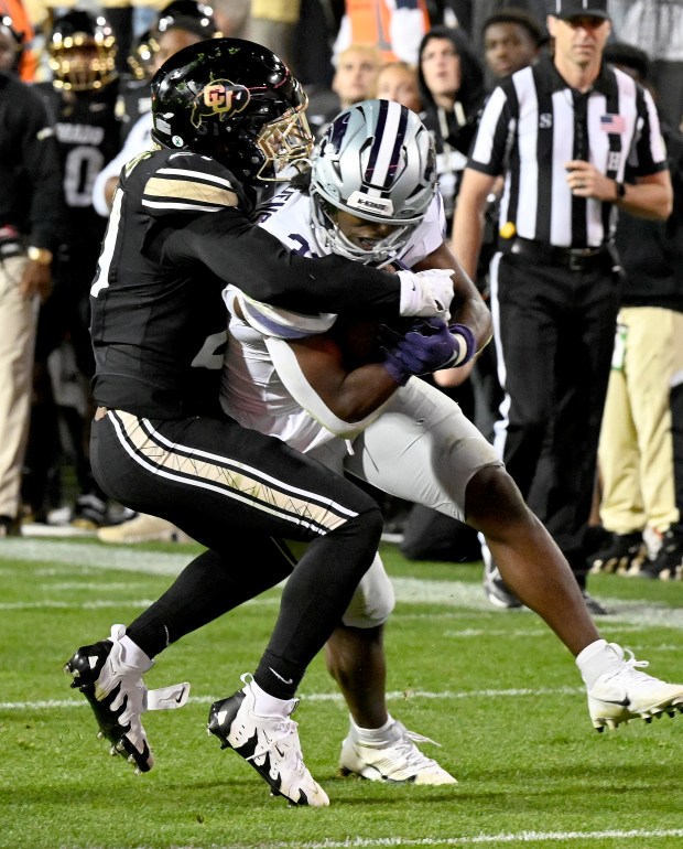 Colorado safety Shilo Sanders, left, tries to tackle Kansas State...