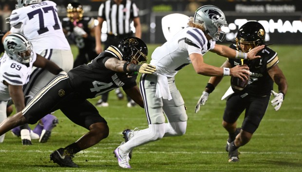 Colorado's Taje McCoy, left, and Cam’Ron Silmon-Craig try to tackle...