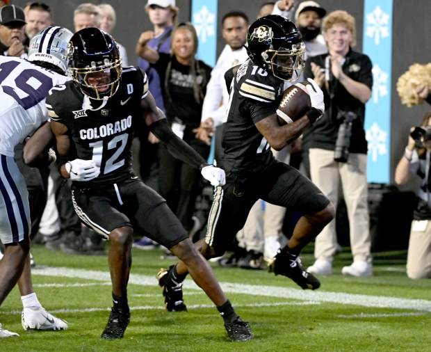 Colorado's LaJohntay Wester, right, gets a block from Travis Hunter...