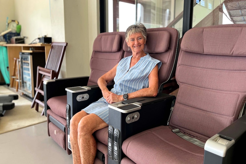 A woman sits on seats that were once inside a QANTAS plane.