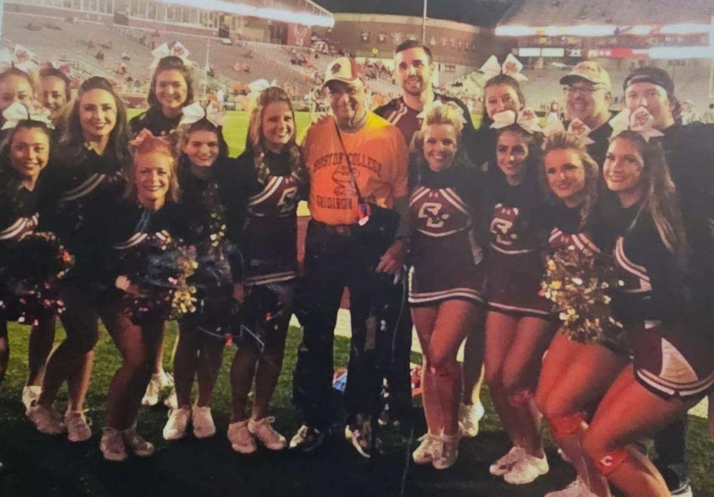 BC Superfan Ron Saloman, 91, poses with BC's cheerleading squad before an Eagles home football game.